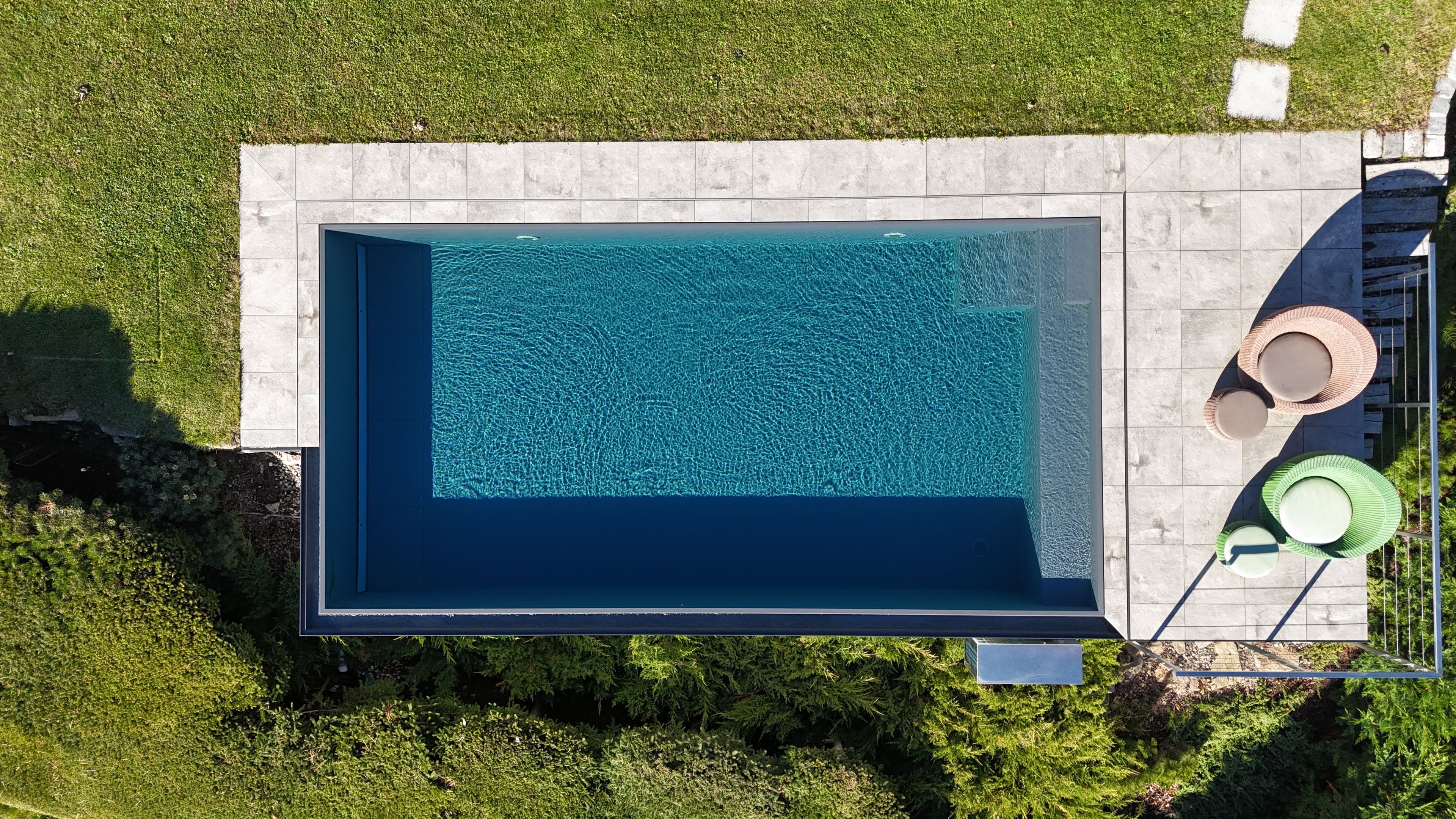 Überlaufpool im Garten aus der Vogelperspektive mit Terrasse und Liegen