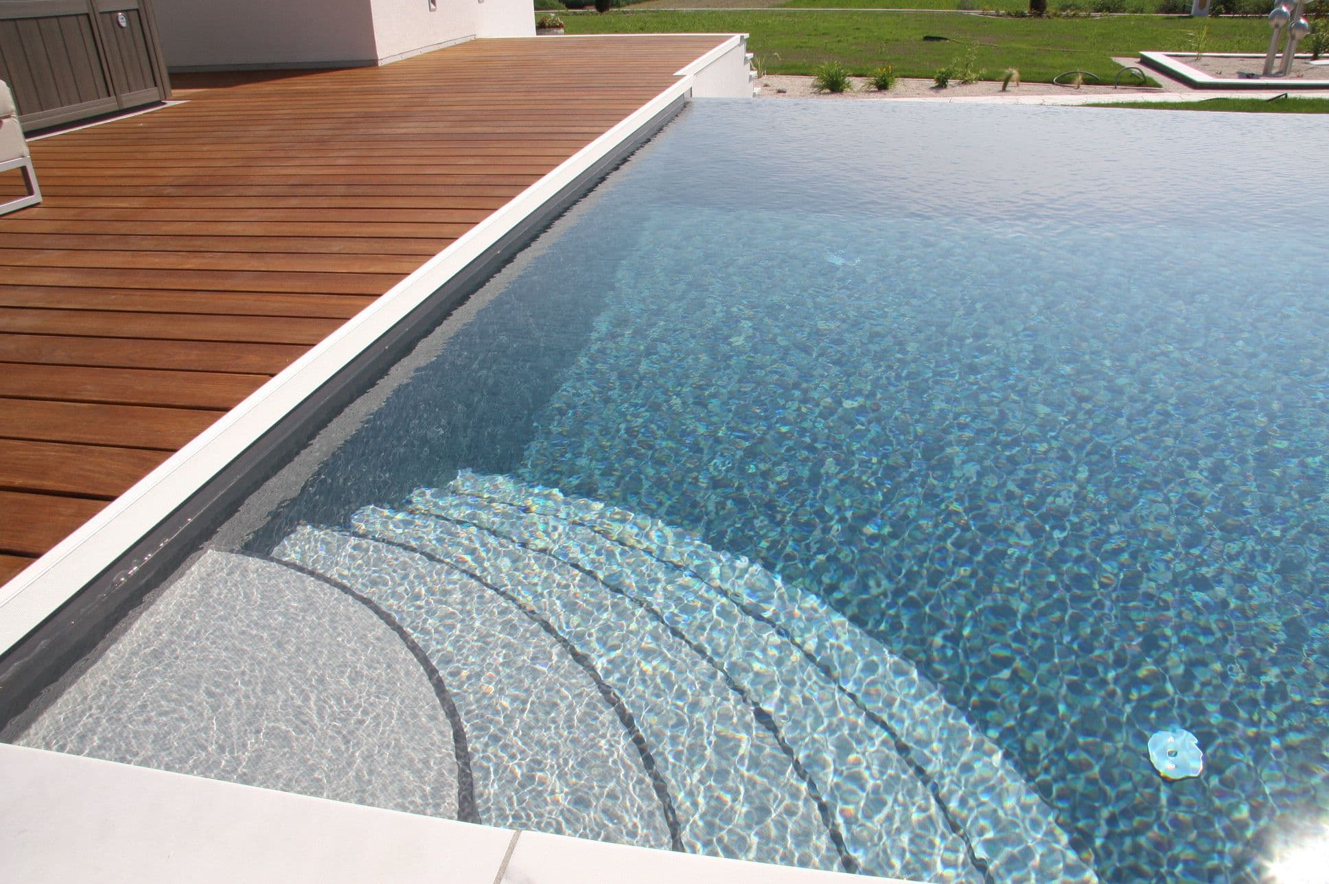 Vierseitige Wasserlinie eines AquaLite-Überlaufpools: Das Wasser wird an allen Seiten gleichmäßig abgezogen