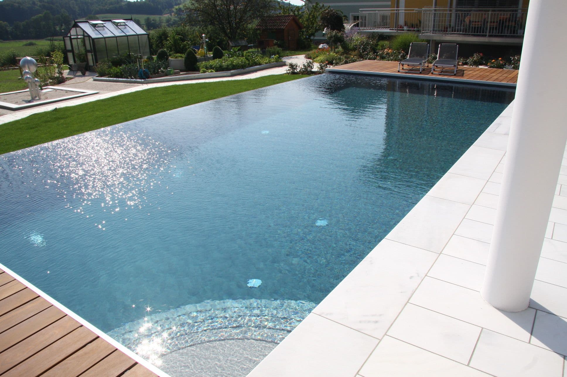 Überlaufpool in Hanglage mit AquaLite-Kaskadenkante zur Hangseite und vierseitigem Überlauf