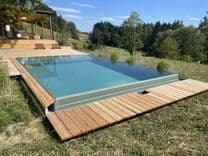 Hangseite des Massivpools mit Kaskadenrinne und freiem Blick in die Landschaft