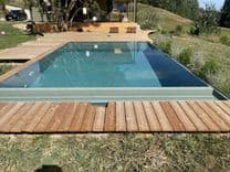 Ruhige Wasserlinie des Massivpools mit AquaLite-Überlaufrinne am Holzdeck