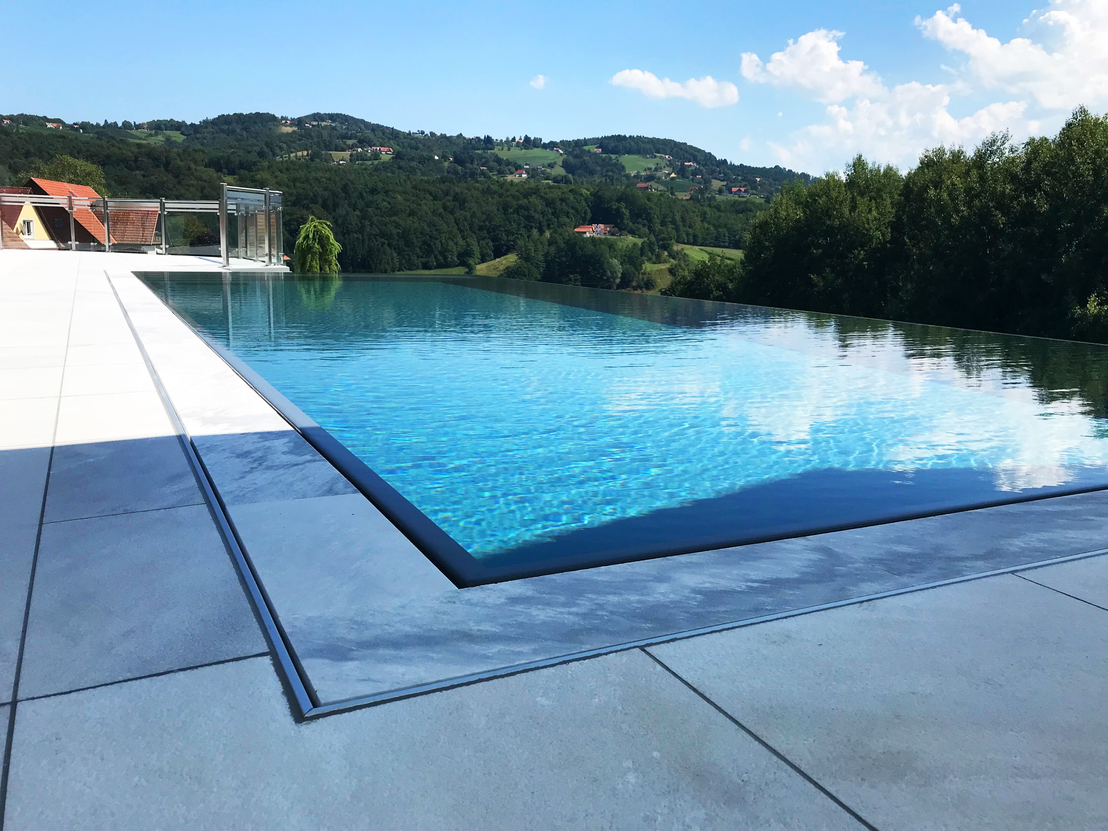 Infinity-Pool mit Kaskadenkante und Blick in die Landschaft