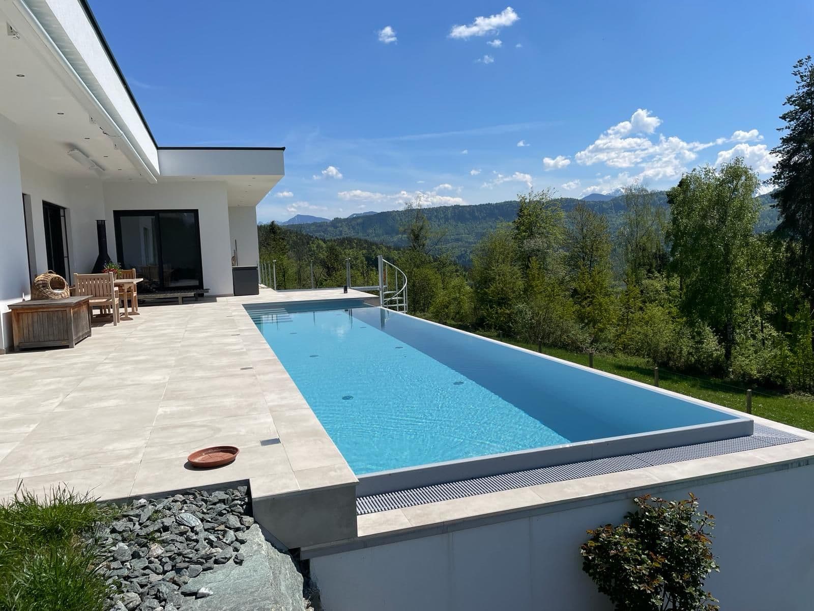 Fertiger Infinity-Pool auf einer Terrasse mit Blick in die hügelige Landschaft