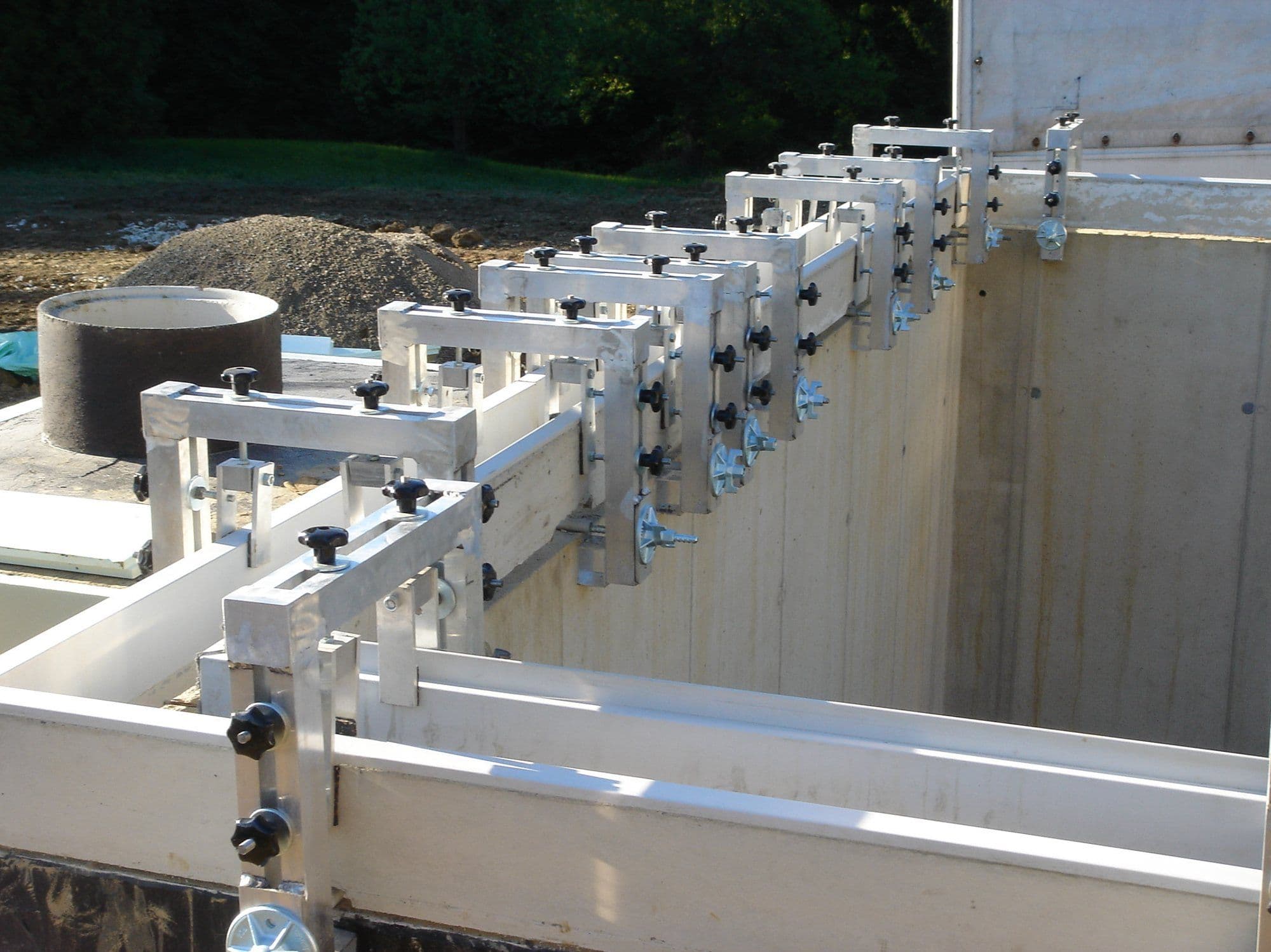 Montagehilfe mit Klemmen zum Ausrichten der Rinnenelemente in Höhe und Flucht auf der fertigen Poolwand